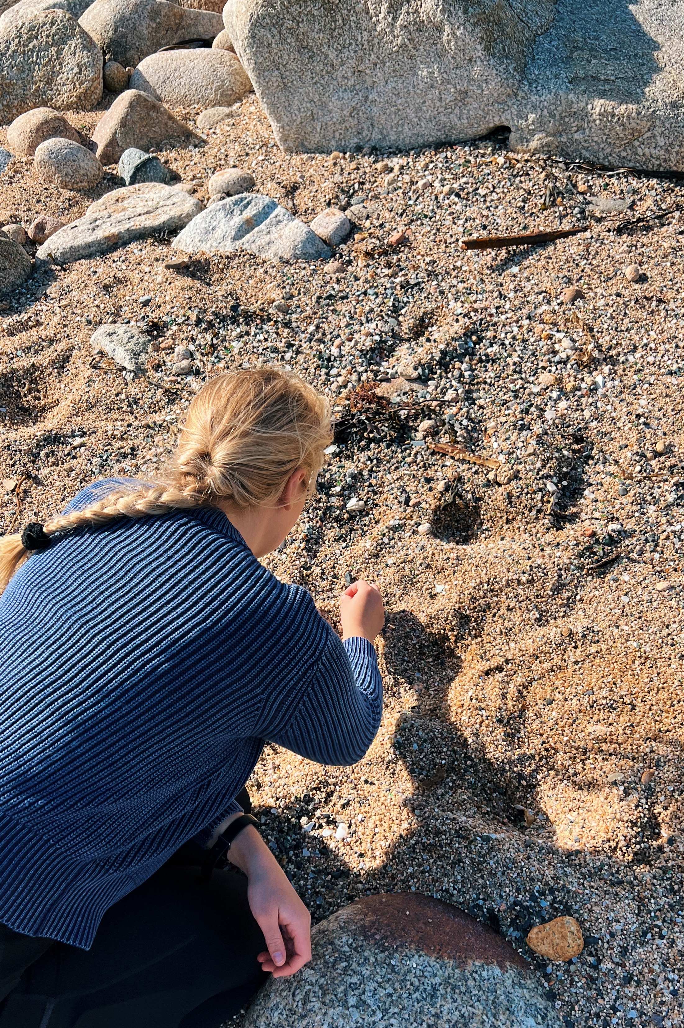 Sadie collecting colorful sea glass on a Cornish beach, gathering inspiration for her handcrafted jewellery collection
